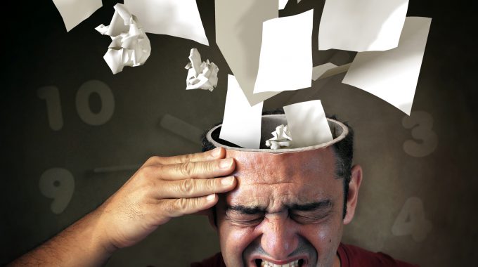 Conceptual Image Of Papers Coming Out Of A Mans Head With Pain Expression